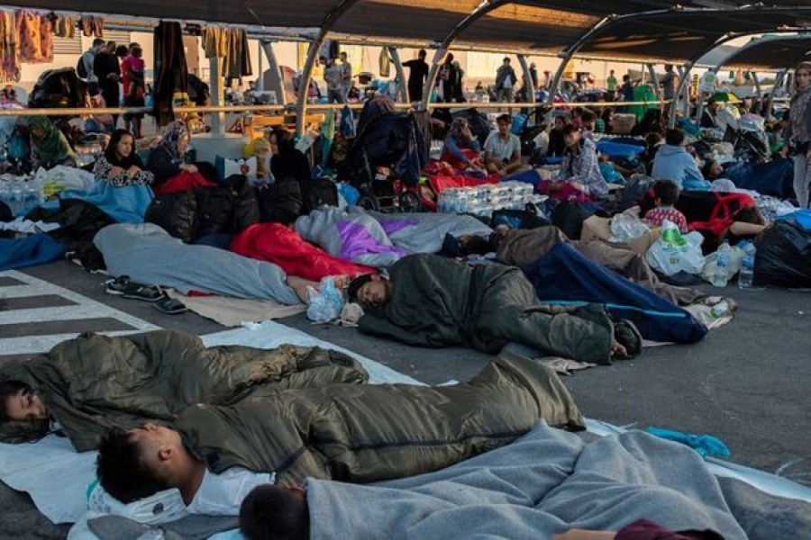 Refugees and migrants sleep at the parking of a supermarket, following a fire at the Moria camp on the island of Lesbos, Greece, September 11, 2020. REUTERS/Alkis Konstantinidis