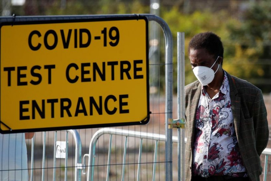 A man stands near a sign for a Covid-19 test centre amid the coronavirus disease (Covid-19) outbreak, in Bolton, Britain on September 17, 2020  — Reuters photo