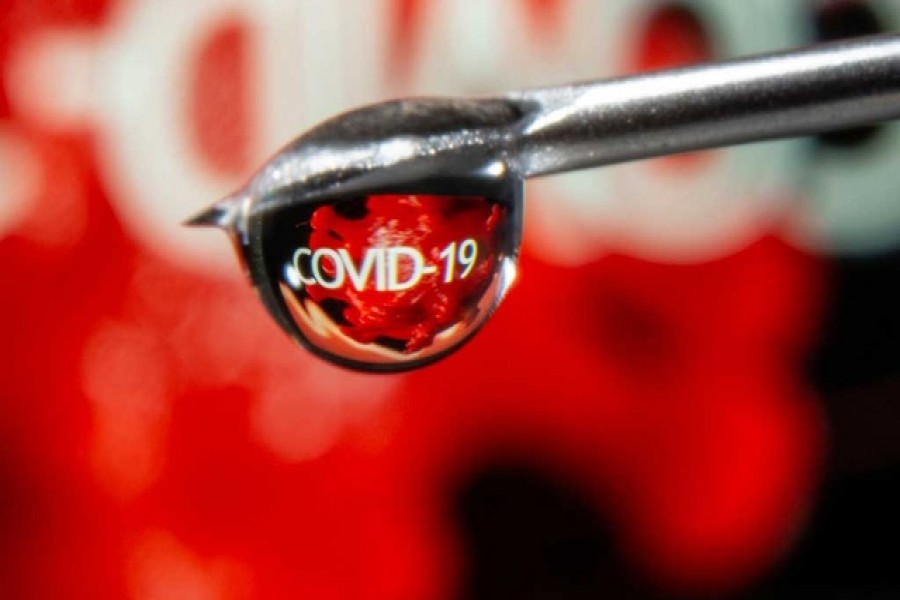 The word "COVID-19" is reflected in a drop on a syringe needle in this illustration taken November 9, 2020. REUTERS