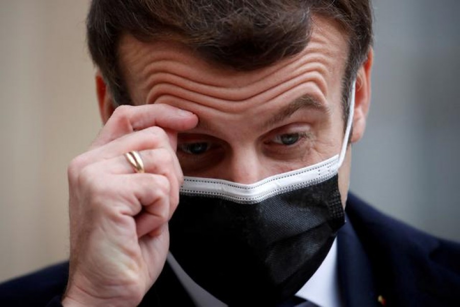 French President Emmanuel Macron, wearing a protective face mask, scratches his brow as he talks to the media next to Portugal's Prime Minister Antonio Costa (not seen) before a meeting at the Elysee Palace in Paris, France, December 16, 2020. REUTERS/Gonzalo Fuentes/File Photo