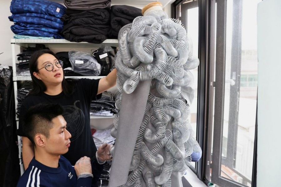 Wang Li-ling inspects a dress at her studio in Taipei — Reuters photo