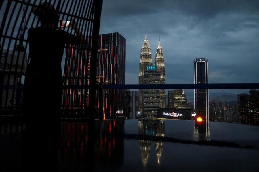 A tourist takes a picture of the city skyline at a bar in Kuala Lumpur, Malaysia, October 9, 2019. Picture taken October 9, 2019. REUTERS/Lim Huey Teng/File Photo
