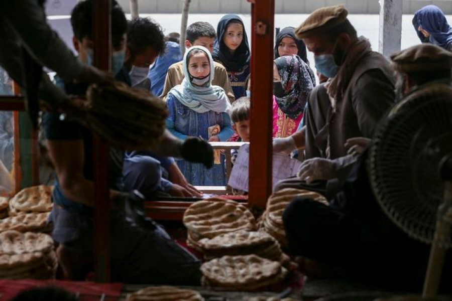 An Afghan family waits for free bread distributed by the government, outside a bakery, during the coronavirus outbreak in Kabul, on May 3, 2020. (Reuters)