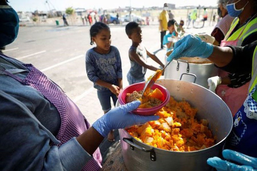 Children queue for food at a school feeding scheme during a nationwide lockdown aimed at limiting the spread of the coronavirus disease (COVID-19) in Blue Downs township near Cape Town, South Africa, May 4, 2020. REUTERS