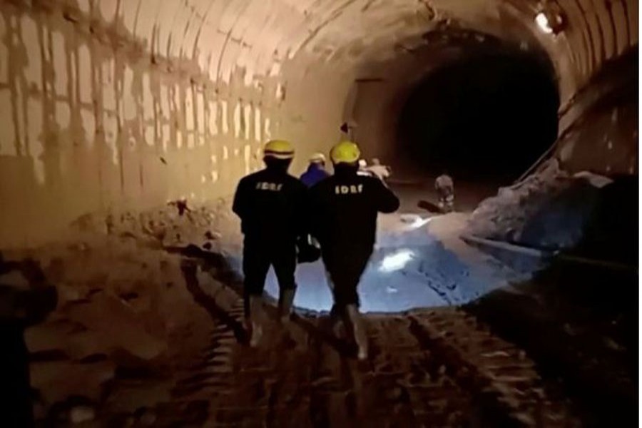 Rescuers walk in a tunnel in Chamoli, Uttarakhand, India during a rescue operation after a glacier burst, in this still frame taken from video dated Feb 09, 2021. REUTERS