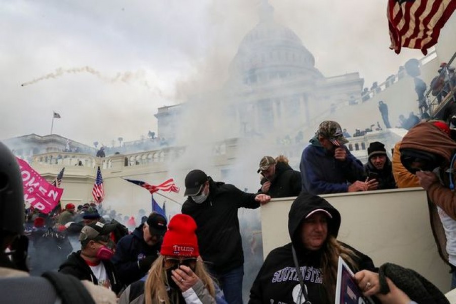 Supporters of US President Donald Trump cover their faces to protect from tear gas during a clash with police officers in front of the US Capitol Building in Washington, US, January 06, 2021 — Reuters/Files