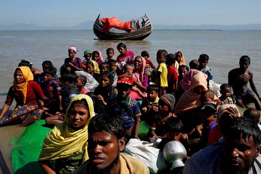 Rohingya refugees sit on a makeshift boat as they get interrogated by the Border Guard Bangladesh after crossing the Bangladesh-Myanmar border, at Shah Porir Dwip near Cox's Bazar, Bangladesh November 9, 2017. REUTERS
