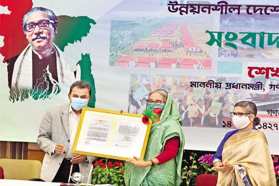 Prime Minister Sheikh Hasina receiving the final recommendation of the UN Committee for Development Policy on its graduation from the LDC category from Finance Minister AHM Mustafa Kamal at a media briefing on Saturday — PID