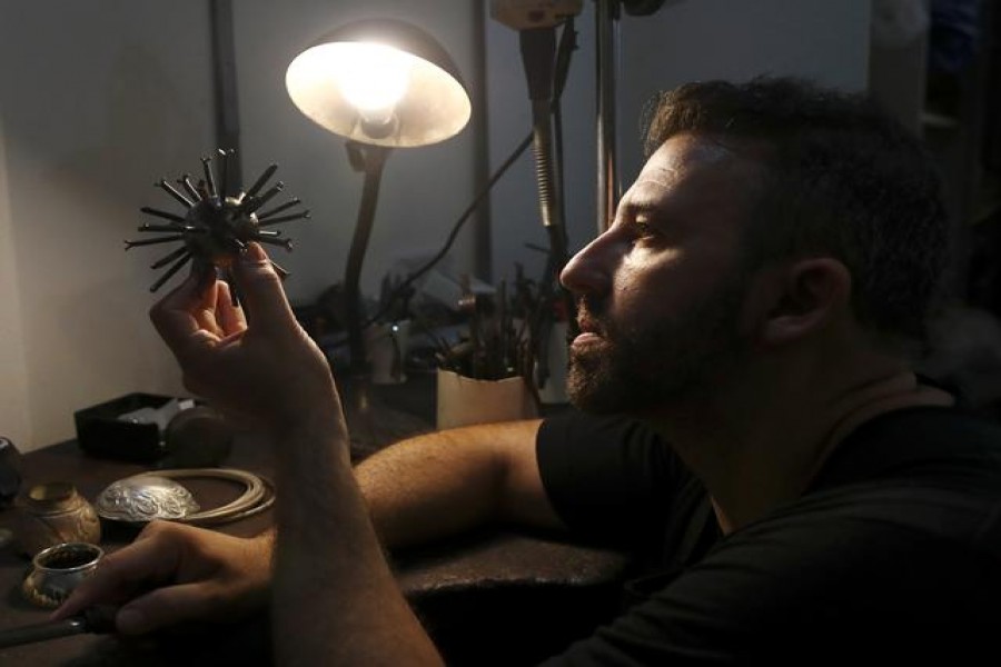 Argentine artist Marcelo Toledo works on an art piece depicting a coronavirus virion made from iron that will be part of the "Museum of the After", at his workshop in Buenos Aires, Argentina March 4, 2021. REUTERS/Agustin Marcarian