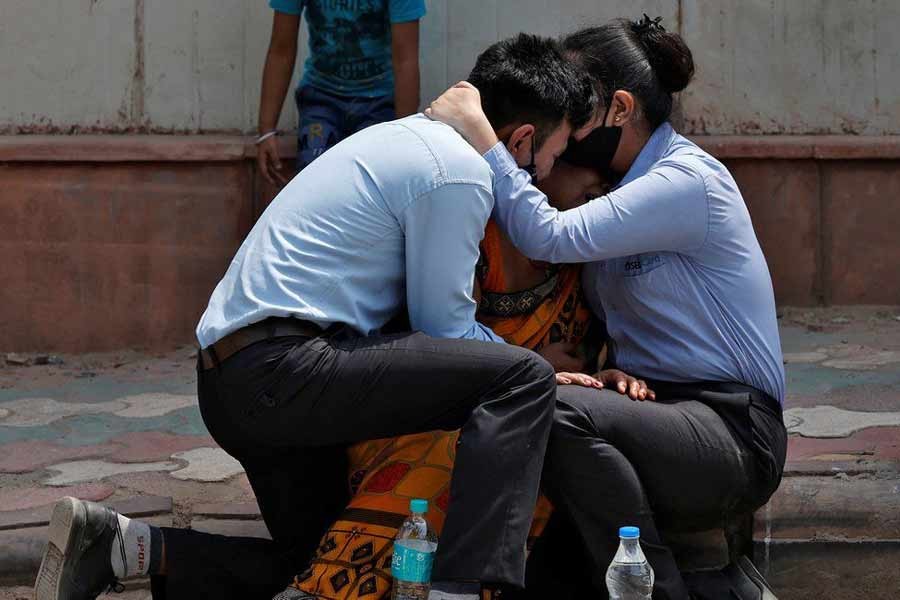 A woman is consoled by her children in Delhi after her husband died from the coronavirus -Reuters file photo