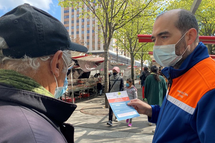 Volunteers from French Protection Civile association hand out leaflets at a fresh producer market to try to persuade Parisians over 55 to take AstraZeneca vaccine, amid the coronavirus disease (COVID-19) pandemic, in Paris, France, April 16, 2021. Reuters