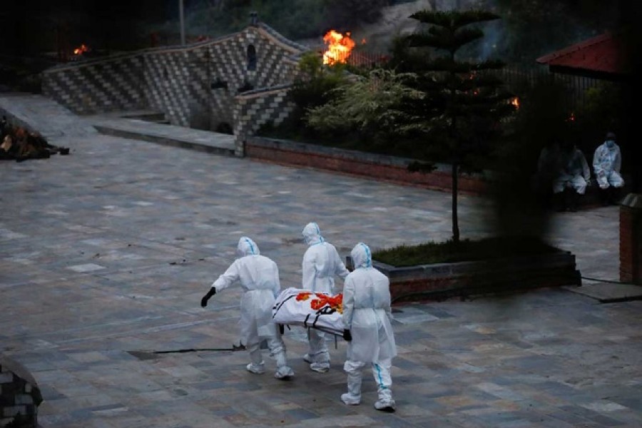 Men wearing personal protective equipment (PPE) carry a body of a coronavirus disease (COVID-19) victim at the crematorium as the country recorded the highest daily increase in deaths since the pandemic began, in Kathmandu, Nepal May 3, 2021 - Reuters photo