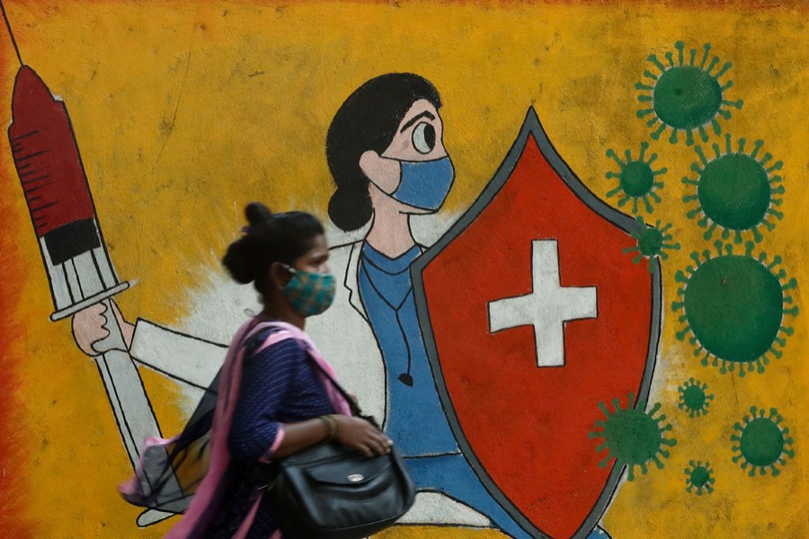 A woman walks past a graffiti on a street, amidst the spread of the coronavirus disease (Covid-19) in Mumbai, India on May 10, 2021 — Reuters photo