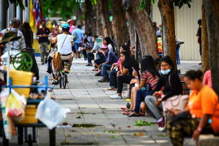 Unemployed people sit on the side of a road in Bangkok on Sept. 15. Thailand’s economy has been impacted severely by the Covid-19 pandemic.