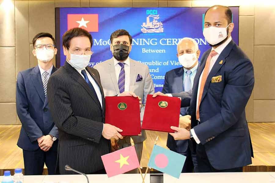 DCCI President Rizwan Rahman and Ambassador of Vietnam Pham Viet Chien are exchanging documents after signing a cooperation agreement on behalf of their respective organisations on Sunday.