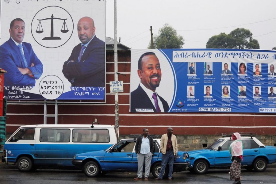 Taxi drivers stand in front of campaign banners of the Ethiopian Prime Minister Abiy Ahmed, and Birhanu Nega, head of the Ethiopian Citizens for Social Justice party, hours before Ethiopia's parliamentary and regional elections, in Addis Ababa, Ethiopia on June 20, 2021 — Reuters photo
