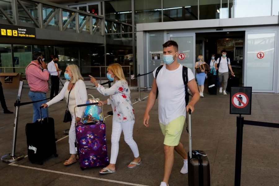 Tourists wearing protective face masks walk with their luggage as they arrive at Malaga-Costa del Sol Airport, in Malaga on Spain, June 7, 2021 — Reuters/Files