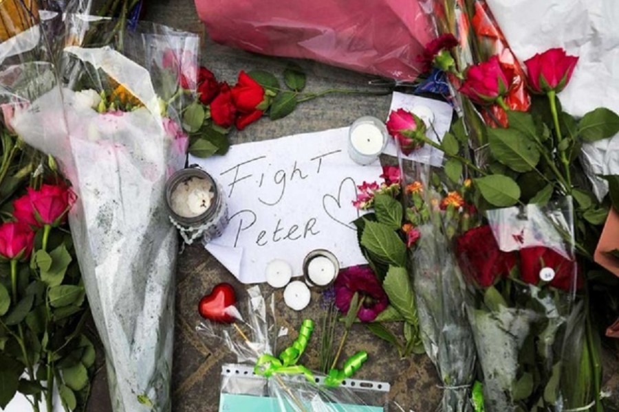 Flowers and a note rest on the place where Dutch celebrity crime reporter Peter R de Vries has been shot and reported seriously injured in Amsterdam, Netherlands, July 7, 2021. REUTERS/Eva Plevier