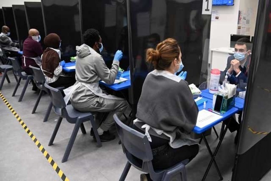 Health workers and volunteers assist as students take coronavirus disease (Covid-19) tests at Harris Academy Beckenham, ahead of full school reopening in England as part of lockdown restrictions being eased, in Beckenham, south east London, Britain, March 5, 2021 — Reuters