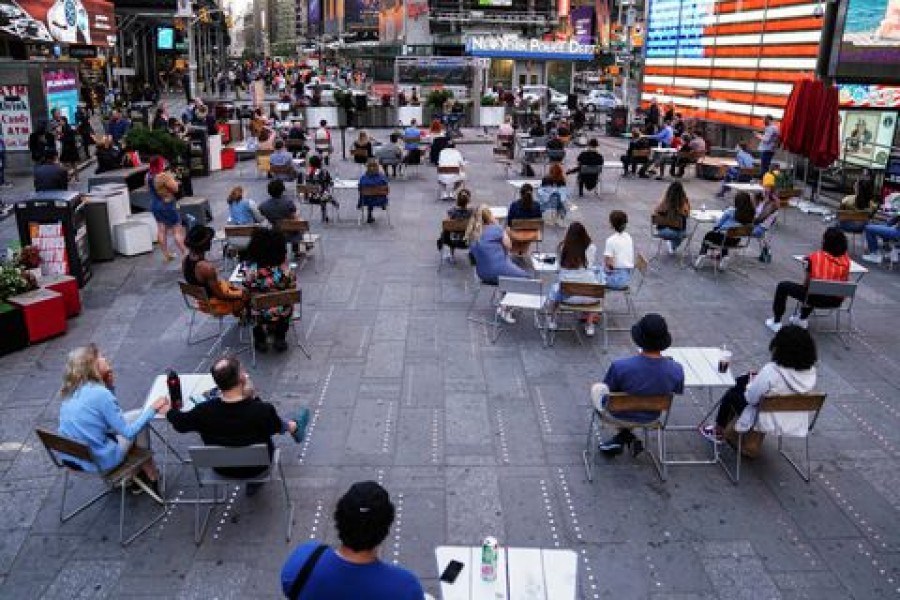 People sit physically distanced while watching a concert in Times Square in the Manhattan borough of New York City, New York, U.S., June 1, 2021. REUTERS/Carlo Allegri/File Photo