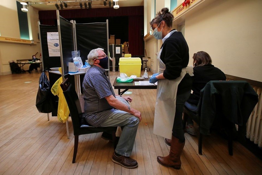 A healthcare worker speaks with an elderly person before administering a dose of the Pfizer-BioNTech coronavirus disease (Covid-19) vaccine at Thornton Little Theatre managed by Wyre Council in Lancashire, Britain, January 29, 2021 — Reuters/Files