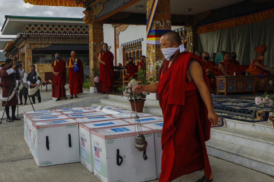 This photograph provided by UNICEF shows monks from Paro's monastic body perform a ritual as 500,000 doses of Moderna COVID-19 vaccine gifted from the United States arrived at Paro International Airport in Bhutan, July 12, 2021. (UNICEF via AP)
