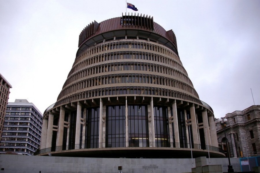 A pedestrian walks past the New Zealand parliament building known as the Beehive in central Wellington, New Zealand, July 3, 2017. Picture taken on July 3, 2017. REUTERS