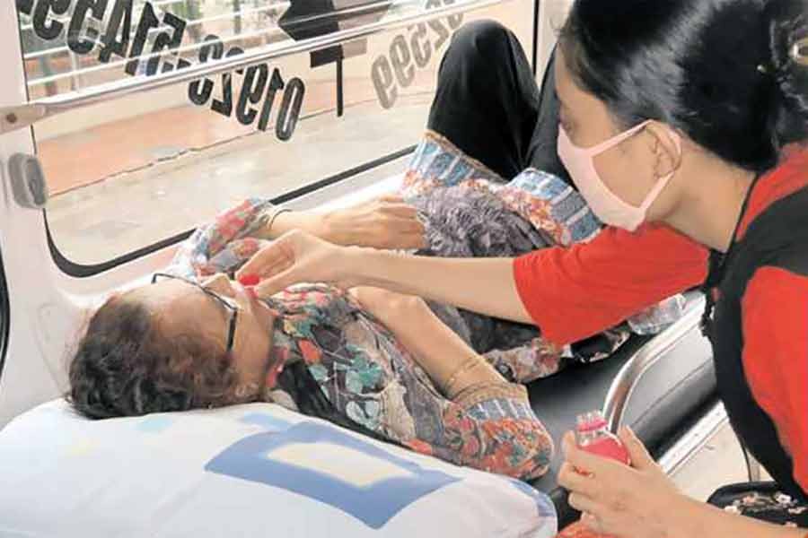 A girl giving a sip of water to her Covid-19 positive mother in an ambulance, moment after she reached Dhaka Medical College Hospital to get admitted there for better treatment. The scene was photographed on Friday —FE photo