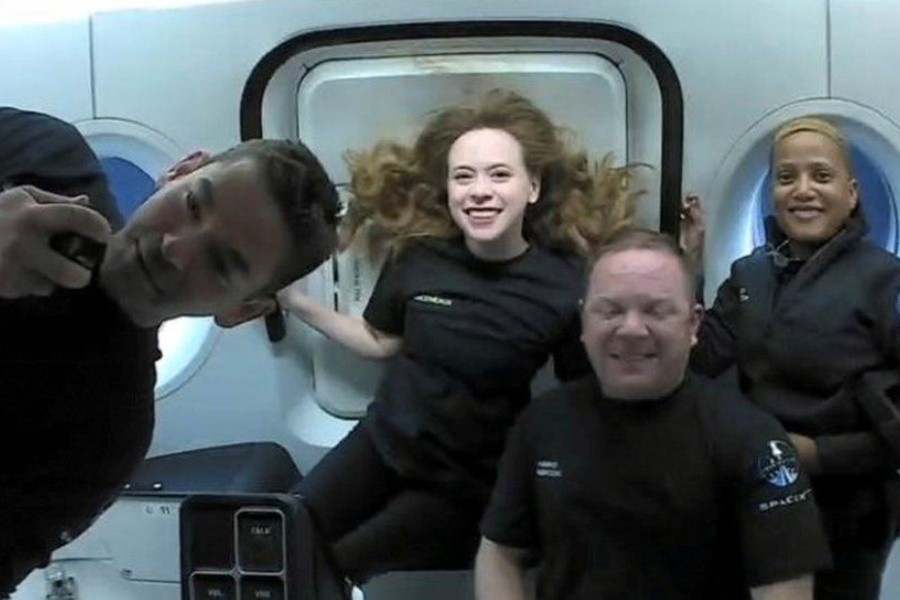 Jared Isaacman, left, and the rest of the team inside the capsule - REUTERS