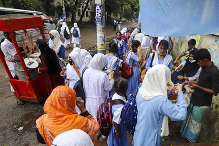 Students crowding a food shop outside Agrani School and College in Dhaka’s Azimpur on Wednesday, breaching physical distancing rules amid the coronavirus pandemic –bdnews24.com photo