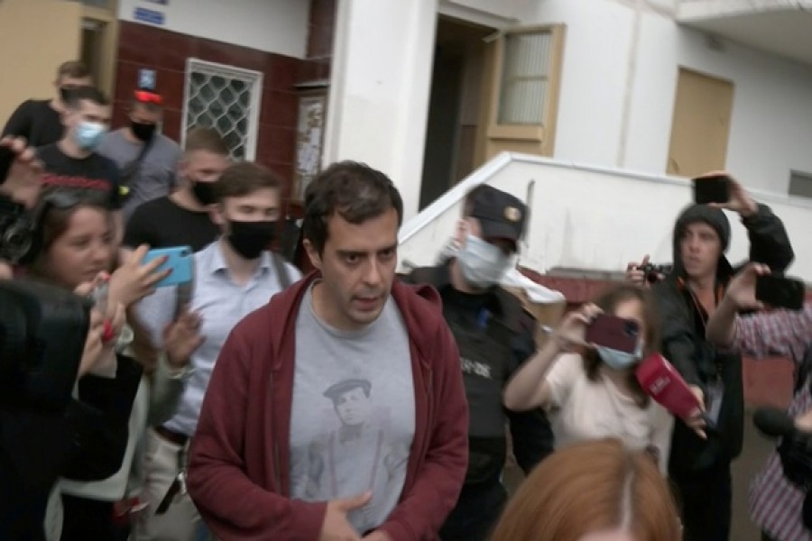 Roman Dobrokhotov, the editor-in-chief of "The Insider" Russian news outlet, who was taken in by Interior Ministry officers for questioning over a slander case, is escorted to a police van in Moscow, Russia July 28, 2021, in this still image taken from video. Video taken July 28, 2021. REUTERS TV/via REUTERS