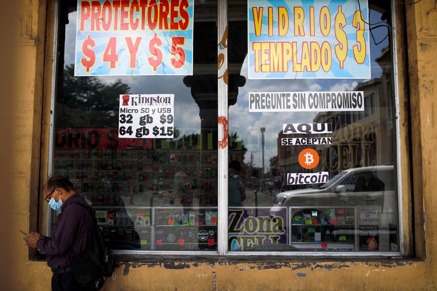 A man stands by a sign that reads, "Bitcoin accepted here", outside a store where the cryptocurrency is accepted as a payment method in San Salvador, El Salvador on September 24, 2021 — Reuters photo