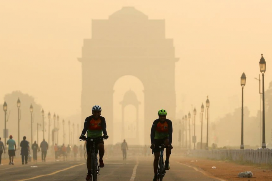 Men ride their bicycles in front of the India Gate shrouded in smog, in New Delhi, India, October 24, 2020. REUTERS/Adnan Abidi