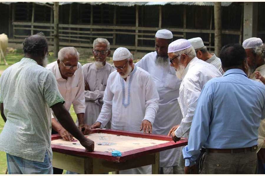 Some elderly persons enjoying carom board game at a social centre in Bangladesh. 	—RIC Photo