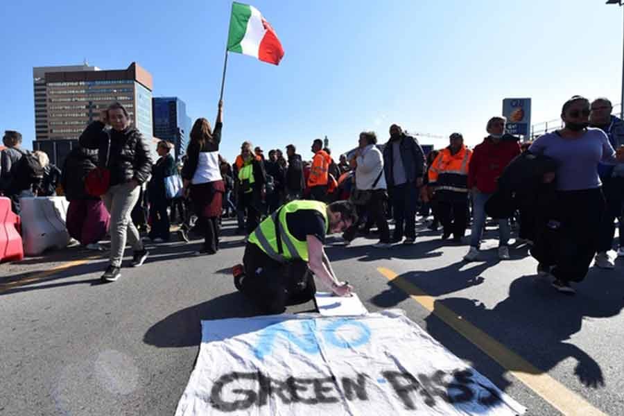 Port workers gathering outside the entrance to protest against the implementation of the COVID-19 health pass, the Green Pass, in the workplace in Genoa of Italy on Friday –Reuters photo