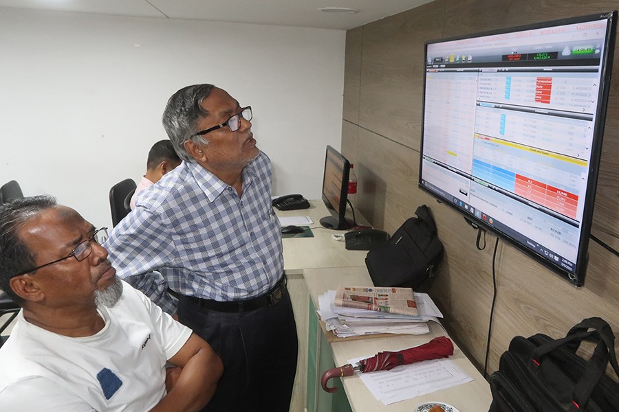 Investors monitoring stock price movements on a television screen at a brokerage house in the capital city — FE/Files
