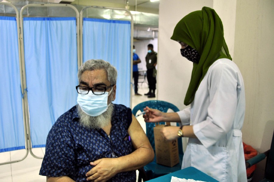 A health worker administers a Covid-19 vaccine shot to an elderly man at Dhaka Medical College Hospital — Focus Bangla file photo