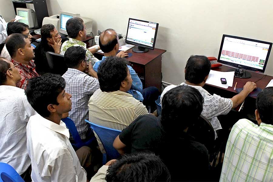 Investors monitoring stock price movements on computer screens at a brokerage house in the capital city — FE/Files