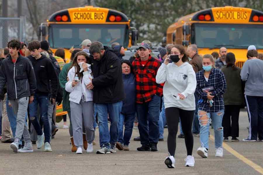 Parents walking away with their kids from the Meijer's parking lot where many students gathered following an active shooter situation at Oxford High School in Oxford of Michigan on Tuesday –Reuters photo