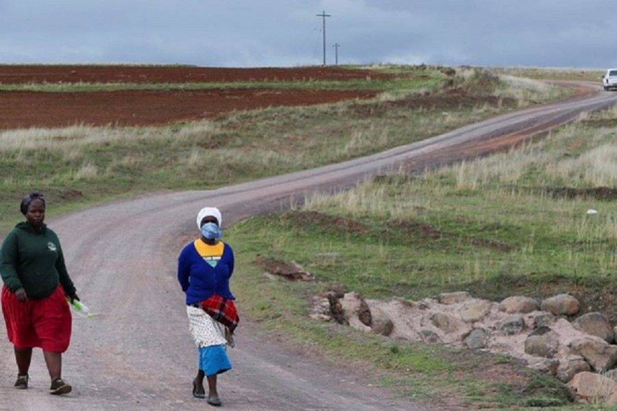 Women walk on a dirt road while using a handkerchief to cover their nose, as the new coronavirus variant, omicron spreads, in Qumanco village in the Eastern Cape province of South Africa, November 30, 2021. REUTERS/Siphiwe Sibeko