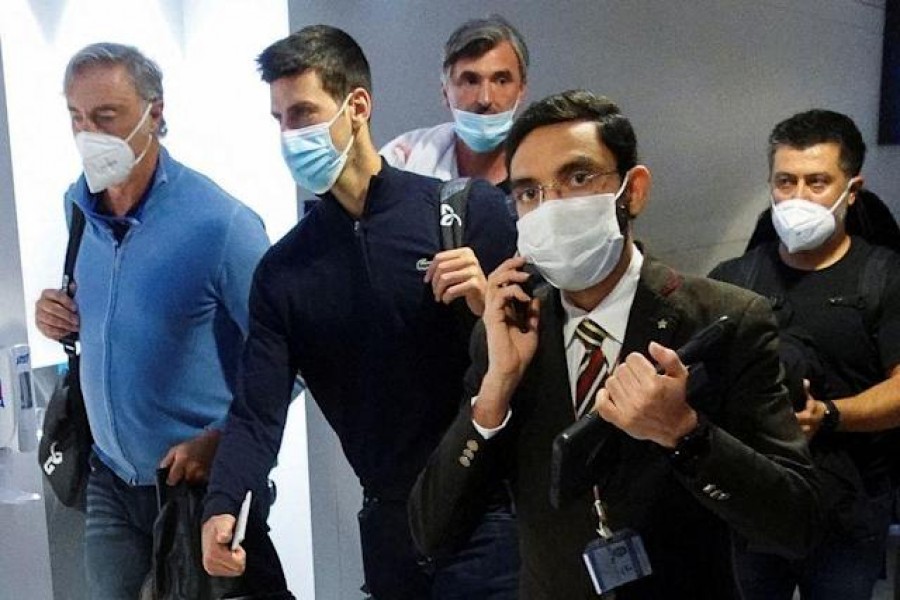 Serbian tennis player Novak Djokovic walks with his team after landing at Dubai Airport after the Australian Federal Court upheld a government decision to cancel his visa to play in the Australian Open, in Dubai, United Arab Emirates, January 17, 2022. REUTERS/Loren Elliott