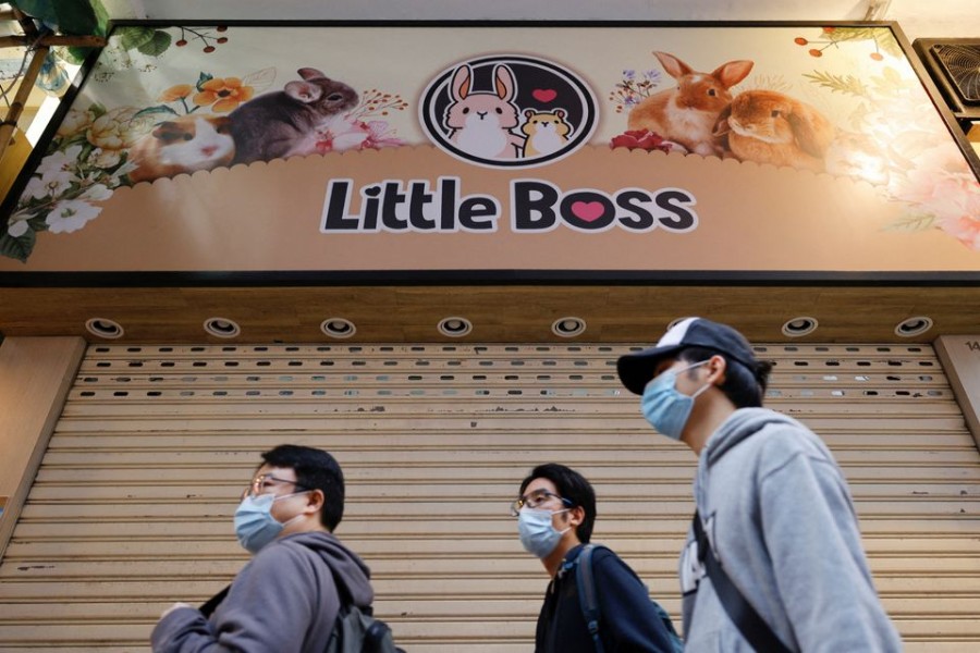 People stand in front of a temporarily closed pet shop after the government announced to euthanise around 2,000 hamsters in the city after finding evidence for the first time of possible animal-to-human transmission of coronavirus disease (COVID-19) in Hong Kong, China, January 18, 2022. REUTERS/Tyrone Siu