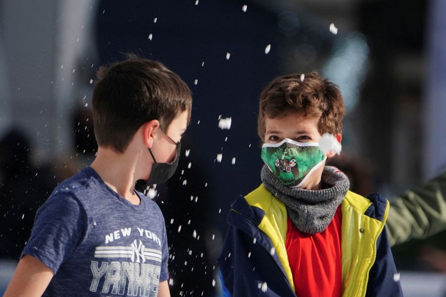 Children wearing protective masks toss snow at each other as they skate at Bryant Park during the coronavirus disease (COVID-19) pandemic in the Manhattan borough of New York City, New York, US, January 14, 2022. REUTERS/Carlo Allegri