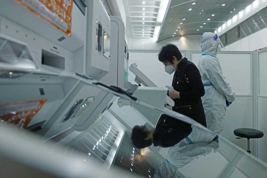 A woman uses an automated teller machine (ATM) at a reopened branch of Shanghai Rural Commercial Bank, amid the coronavirus disease (COVID-19) in Shanghai, China May 20, 2022. REUTERS