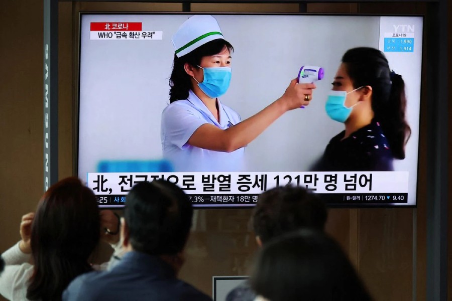 People watch a TV broadcasting a news report on the coronavirus disease (COVID-19) outbreak in North Korea, at a railway station in Seoul, South Korea, May 17, 2022. REUTERS/Kim Hong-Ji/File Photo