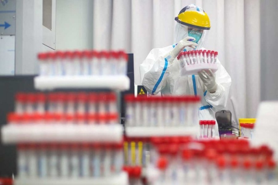 A medical staff in protective suit works at a nucleic acid testing laboratory of Nanjing First Hospital following a citywide mass testing for the coronavirus disease (COVID-19) in Nanjing, Jiangsu province, China July 24, 2021. Reuters
