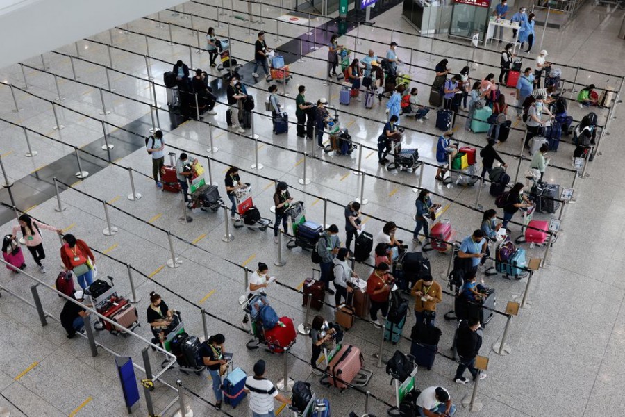 Travellers queue up for shuttle bus to quarantine hotels at the Hong Kong International Airport, amid the coronavirus disease (COVID-19) pandemic, in Hong Kong, China, August 1, 2022. REUTERS/Tyrone Siu