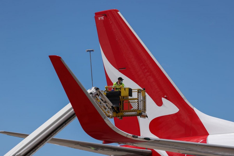 An aircraft appearance crew member cleans an aircraft as Qantas begins preparing and equipping planes for the return of international flights, in anticipation of Australia easing coronavirus disease (COVID-19) border regulations, at Sydney Airport in Sydney, Australia, October 21, 2021. REUTERS/Loren Elliott
