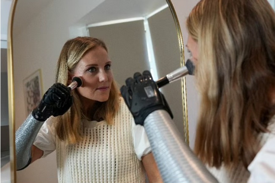 Jessica Smith, a former Australian Paralympic Swimmer, poses for a picture while applying make-up with her new bionic hand that improves the speed of movement and sensitivity of touch, according to the company, in London, Britain, Aug 12, 2022. REUTERS