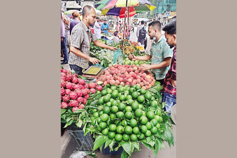 People are getting inclined increasingly to buy locally-grown fruits following unbridled hike in the prices of the imported ones. The photo was taken from Motijheel area of the city on Wednesday. — FE Photo